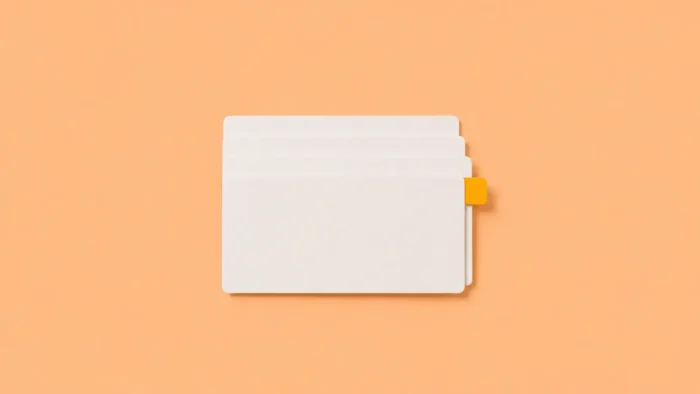 Illustration de quatre fiches cartonnées blanches légèrement superposées et parfaitement alignées. Une seule fiche comporte un petit onglet visible qui dépasse discrètement du côté droit pour mettre en avant une information importante est immédiatement repérée grâce à une organisation efficace.
