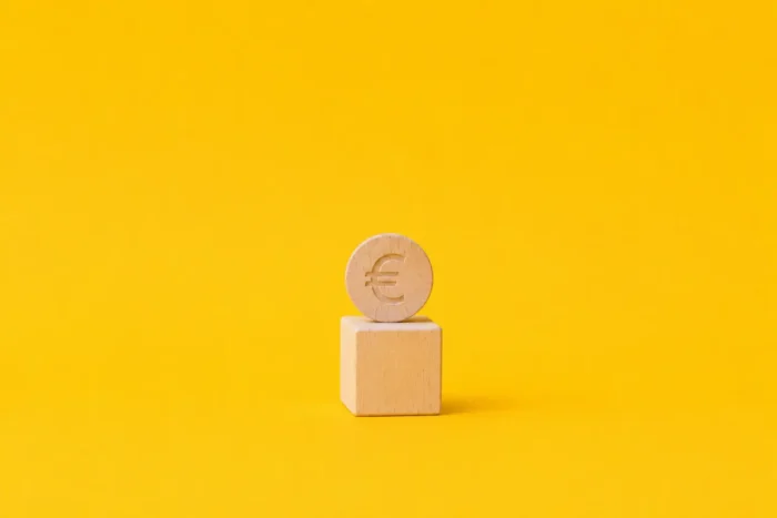 Illustration d'un cube et d'un euro en bois pour mettre en lumière le processus mal connu de l'acompte sur salaire, qui est pourtant un droit encadré par le code du travail.