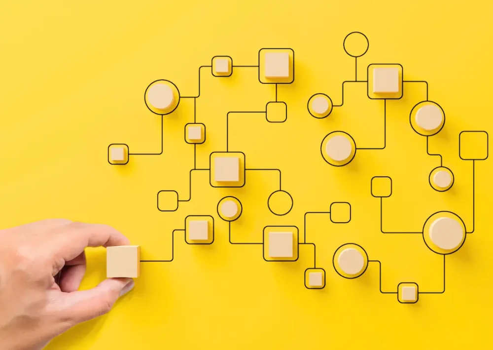 Réseau d'automatisation des processus RH avec cubes en bois sur fond jaune, illustrant l'intégration via l'API REST de Silae.