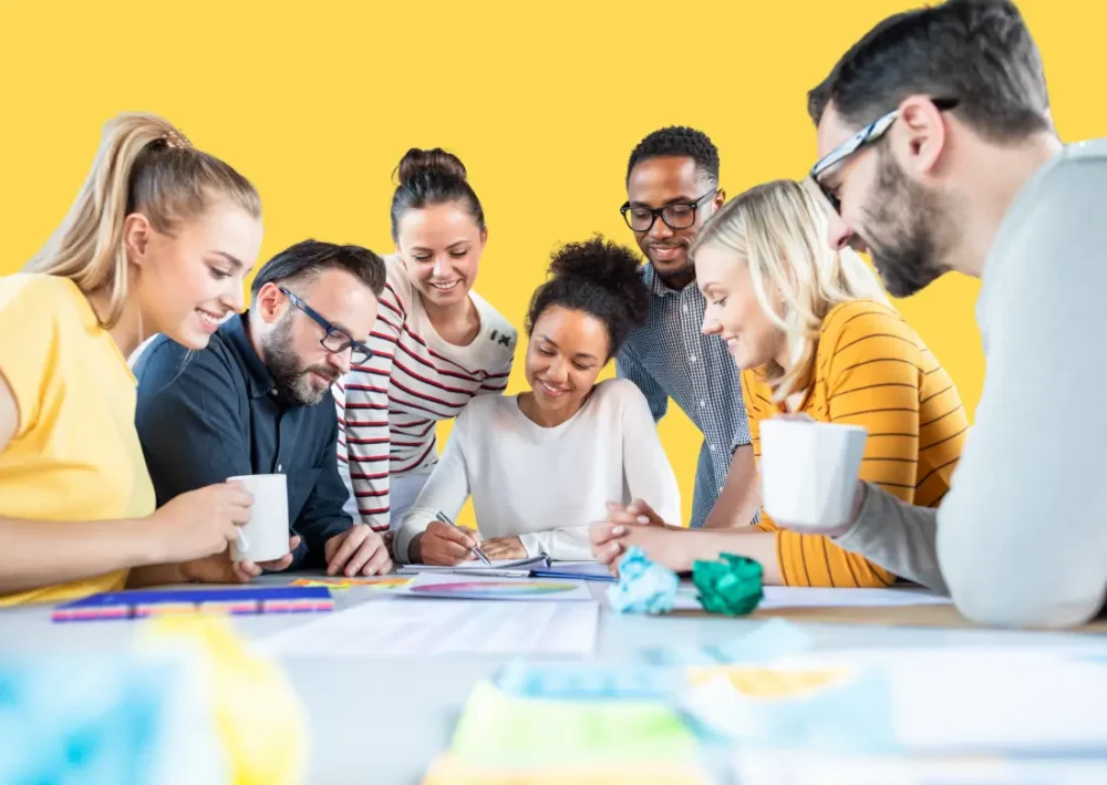 Équipe en réunion collaborative autour d’une table, illustrant l’efficacité d’un SIRH pour la gestion du temps et des ressources humaines.