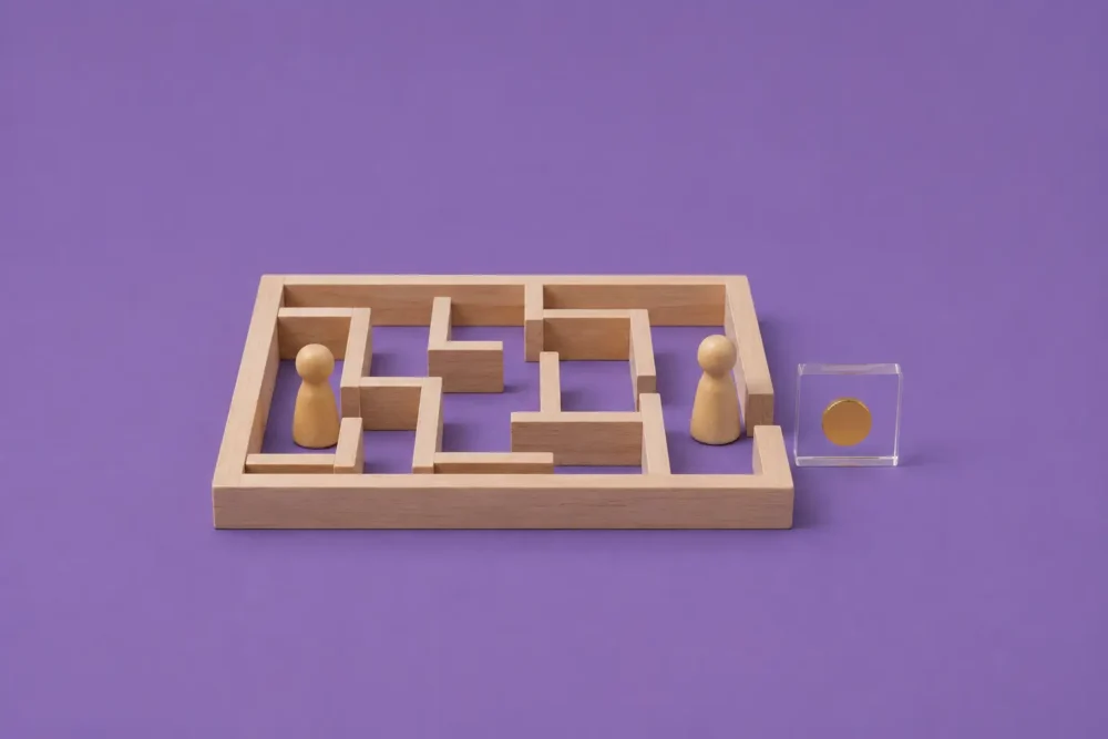Illustration d'un labyrinthe dans lequel figure deux pions en bois dont l'un trouve plus facilement la sortie, afin d'illustrer l'accès très inégal à la rupture conventionnelle selon le statut, l'âge et le CSP des salariés.